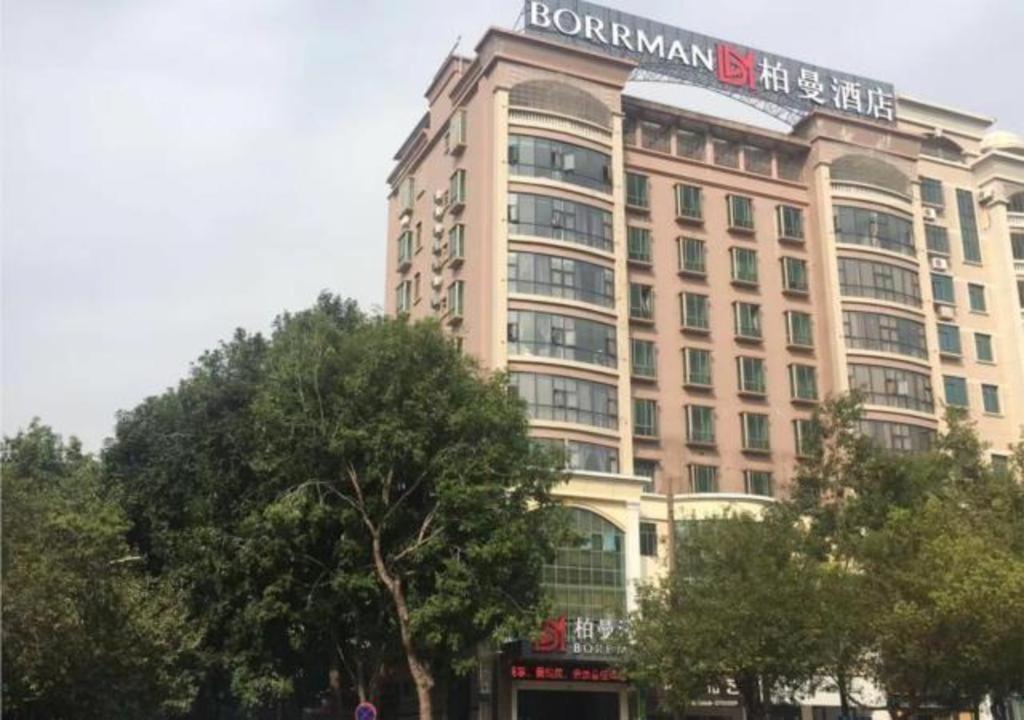 a large building with a sign on top of it at Borrman Hotel Maoming 7th Youcheng Road Municipal Government in Maoming