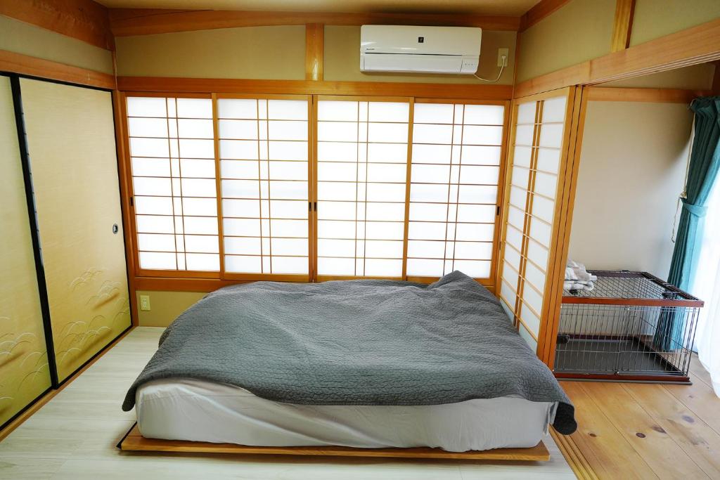 Ioki宿や晴的一间设有床铺的卧室,位于带窗户的房间内