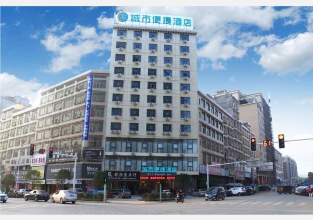 wysoki biały budynek z napisem na górze w obiekcie City Comfort Inn Shaoyang Wugang w mieście Wugang
