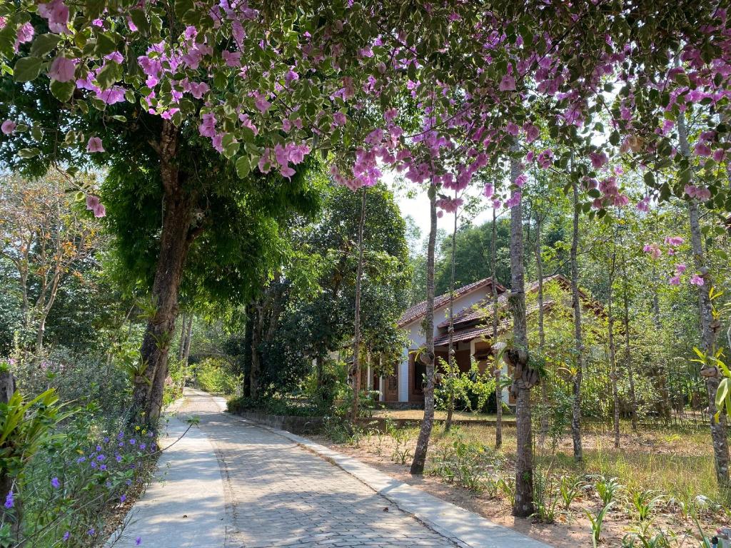 a path leading to a house with purple flowers at The Garden House Phu Quoc Resort in Phu Quoc
