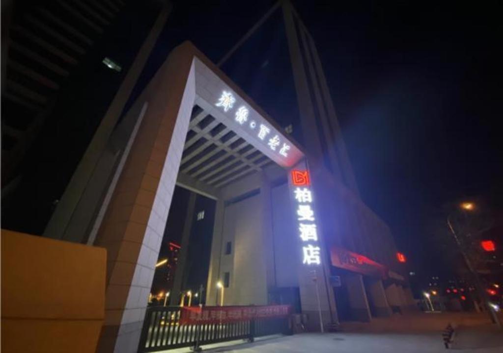 Borrman Hotel Ji'nan Aoti Center East Provincial Hospital في Licheng: مبنى عليه علامة نيون في الليل