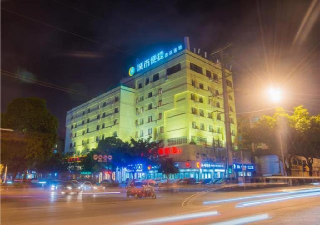 a building on a city street at night with traffic at City Comfort Inn Liuzhou Longtan Park Ma'anshan Baiyun in Liuzhou