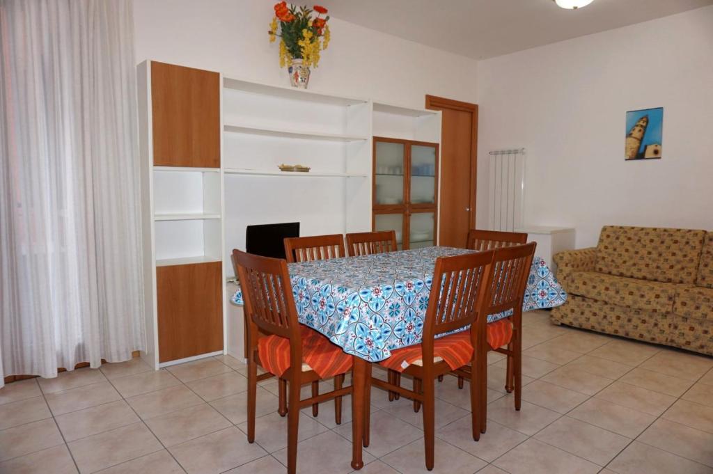 jadalnia ze stołem, krzesłami i kanapą w obiekcie Comfortable flat with pool - Beahost w mieście Porto Santa Margherita di Caorle
