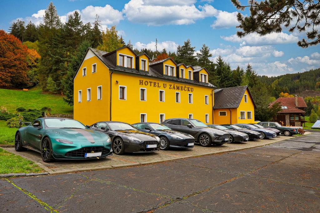 a row of cars parked in front of a yellow building at Hotel U Zámečku Cihelny in Karlovy Vary