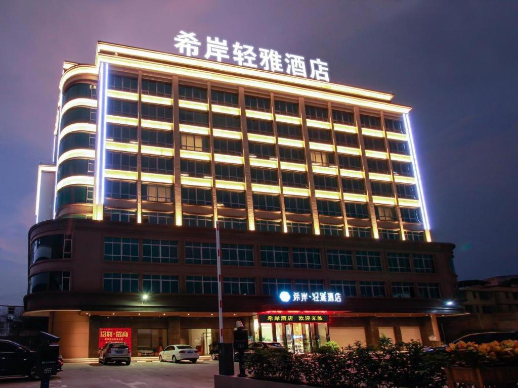 a large building with a sign on top of it at Xana Lite Huizhou Railway Station in Ruhu