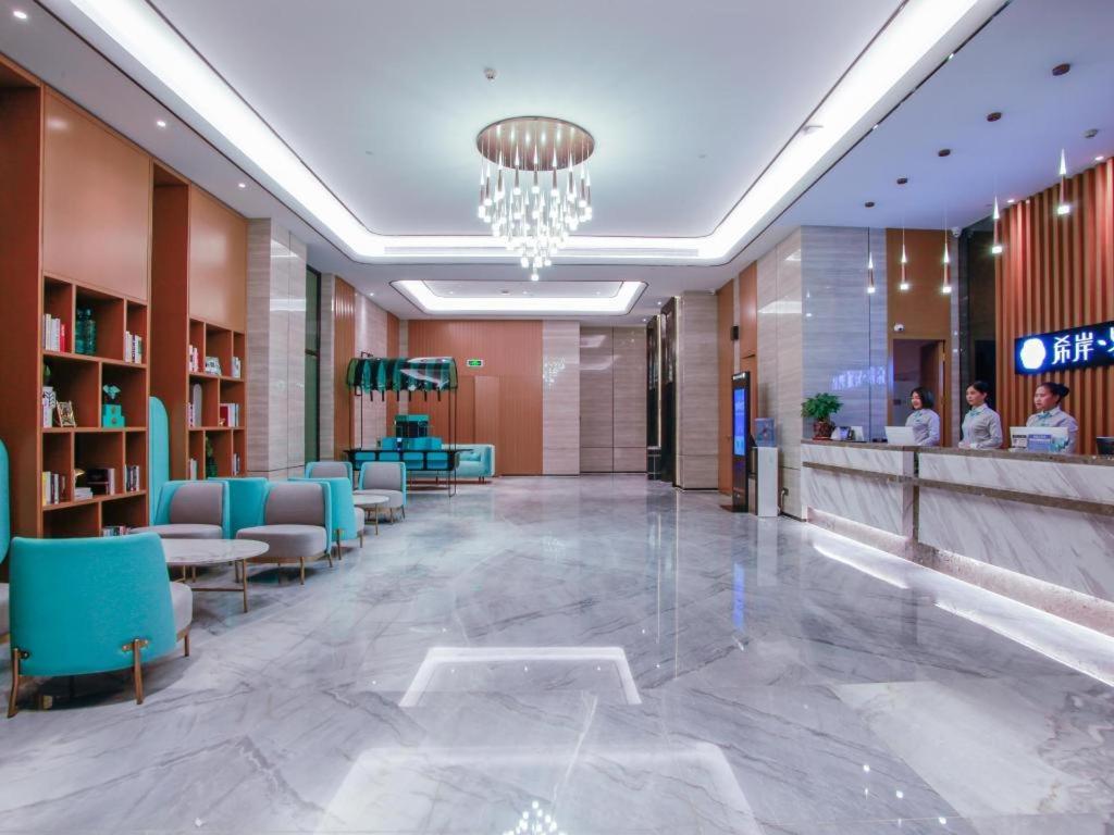 a lobby of a hospital with blue chairs at Xana Lite Huizhou Railway Station in Huizhou