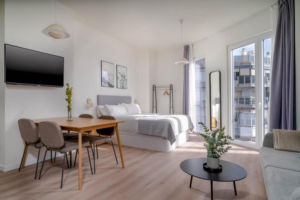 a bedroom with a bed and a table and a couch at Limehome Valencia Carrer de Sant Jacint in Valencia