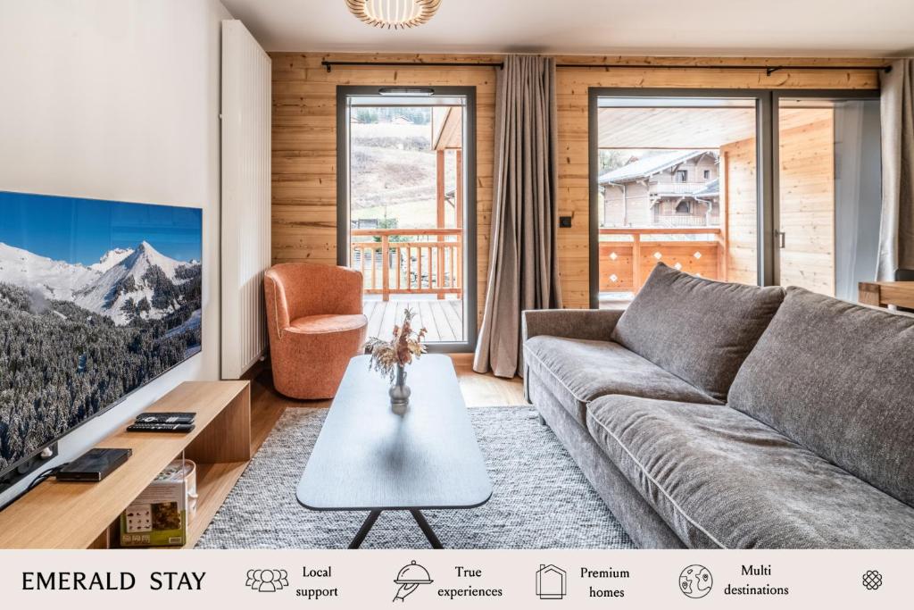a living room with a couch and a tv at Apartment Edelweiss Les Gets - BY EMERALD STAY in Les Gets
