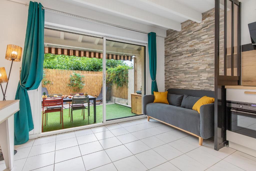 a living room with a couch and a sliding glass door at Villa Forlittoral in Le Grau-dʼAgde