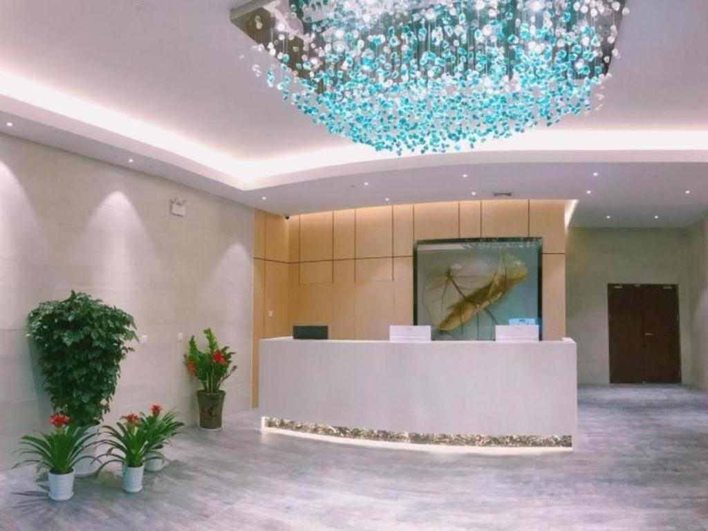- un hall avec un lustre bleu dans un bâtiment dans l'établissement GreenTree Inn Express Guangxi Nanning Mingyang Avenue Nanning Airport, à Tanbai