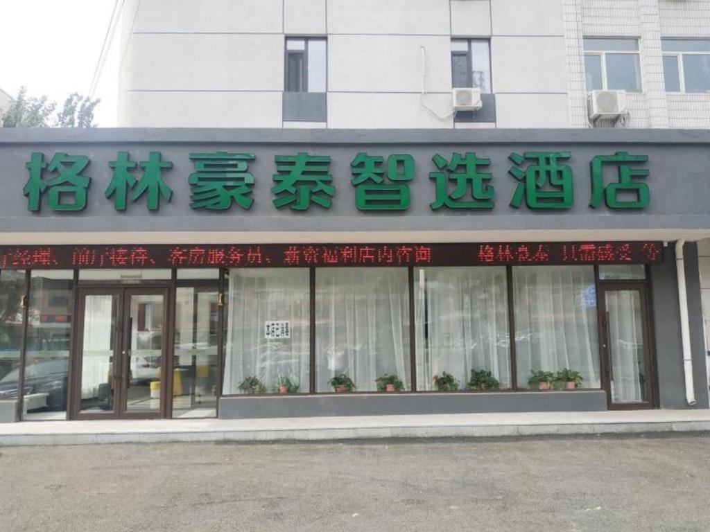 un magasin devant un bâtiment avec écriture sur celui-ci dans l'établissement GreenTree Inn Shenyang Huanggu District Union Building, à Shenyang
