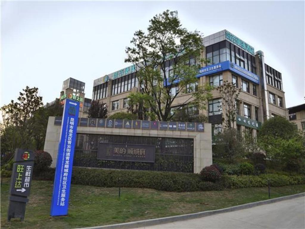 un edificio con una señal delante de él en City Comfort Inn Kunming Flower City Midea Shuncheng Mansion, en Kunming