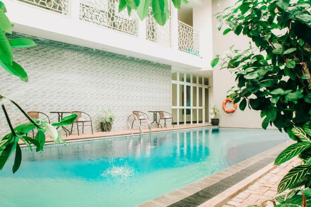 uma piscina num edifício com cadeiras e árvores em HOTEL SG17 em Tuban