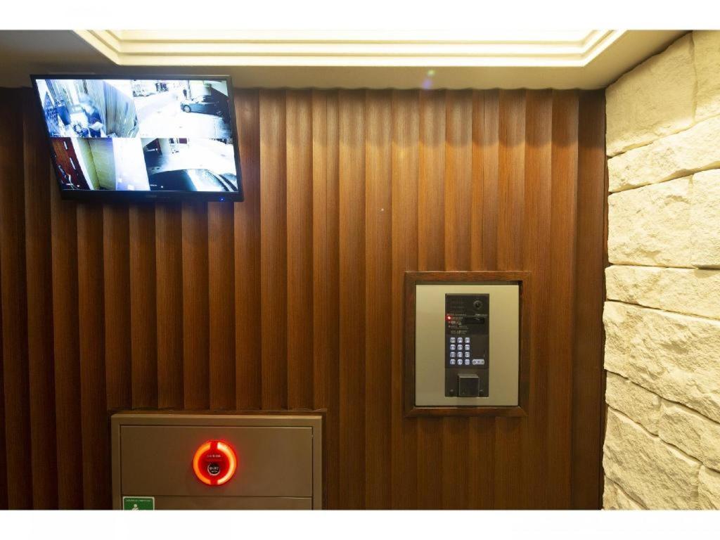 un televisor en una pared con un teléfono público en Coruscant Hotel Nagasaki Station2 en Asahimachi