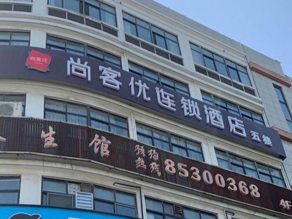 un edificio con un cartello sul lato di Thank Inn Hotel Jiangsu Wuxi High-Tech Zone Ruigang Pedestrian Street a Daqiangmen
