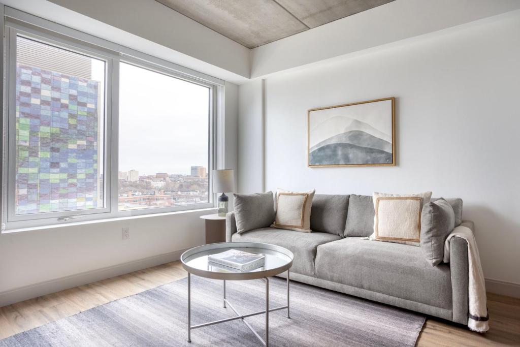 a living room with a couch and a table at Blueground Fenway gym nr food shops BOS-1027 in Boston