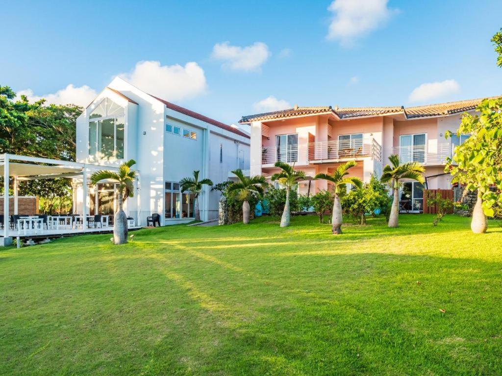 an exterior view of a house with a yard at The Beach Terrace Hotel AO Ishigaki in Ishigaki Island