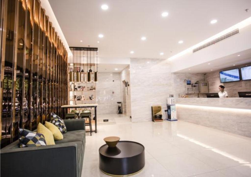 a lobby with a couch and a table and a bar at City Comfort Inn Yangzhou Dongguan Street Heyuan in Yangzhou