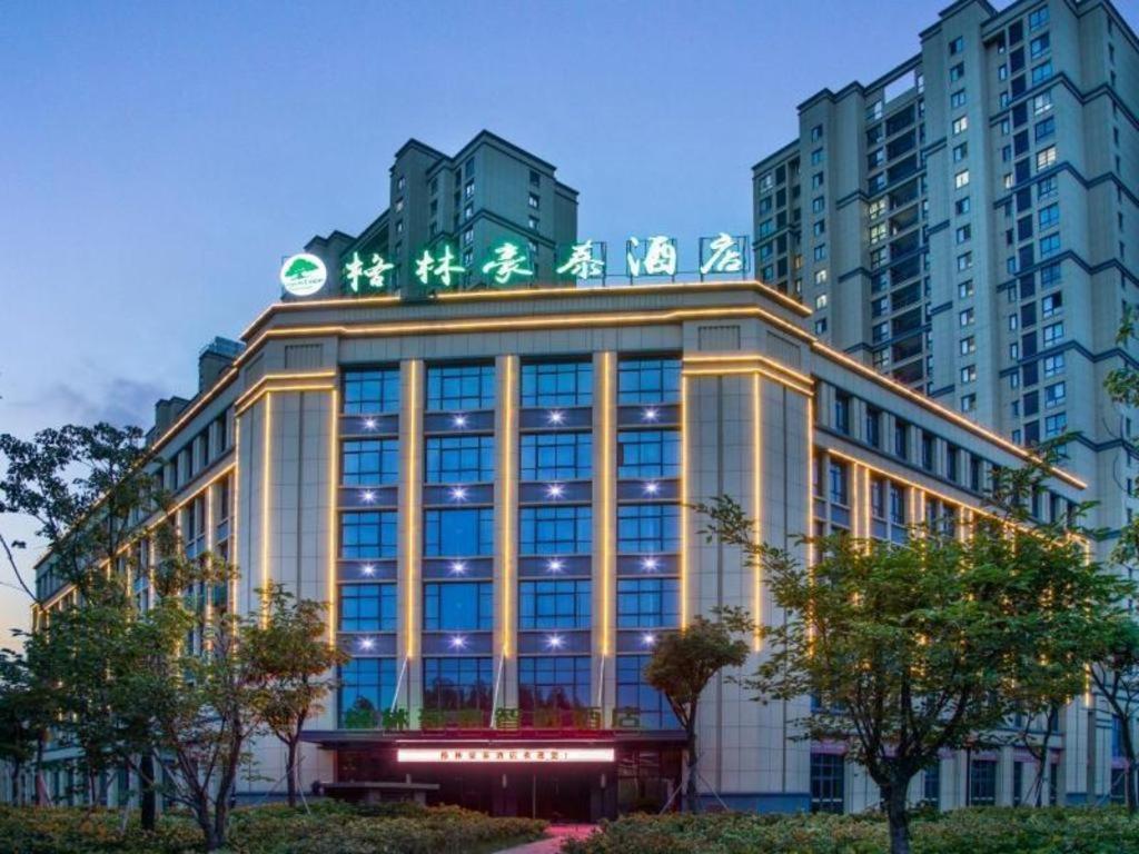 a building with a sign on the top of it at Green Tree Inn Express Huai'an Huaiyin District Jiangxi Road Normal University in Huai'an