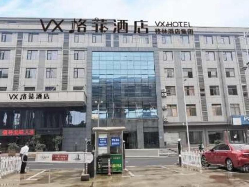 um edifício com um carro estacionado em frente em VX Hotel Shangrao High-Speed Railway Station em Shangrao