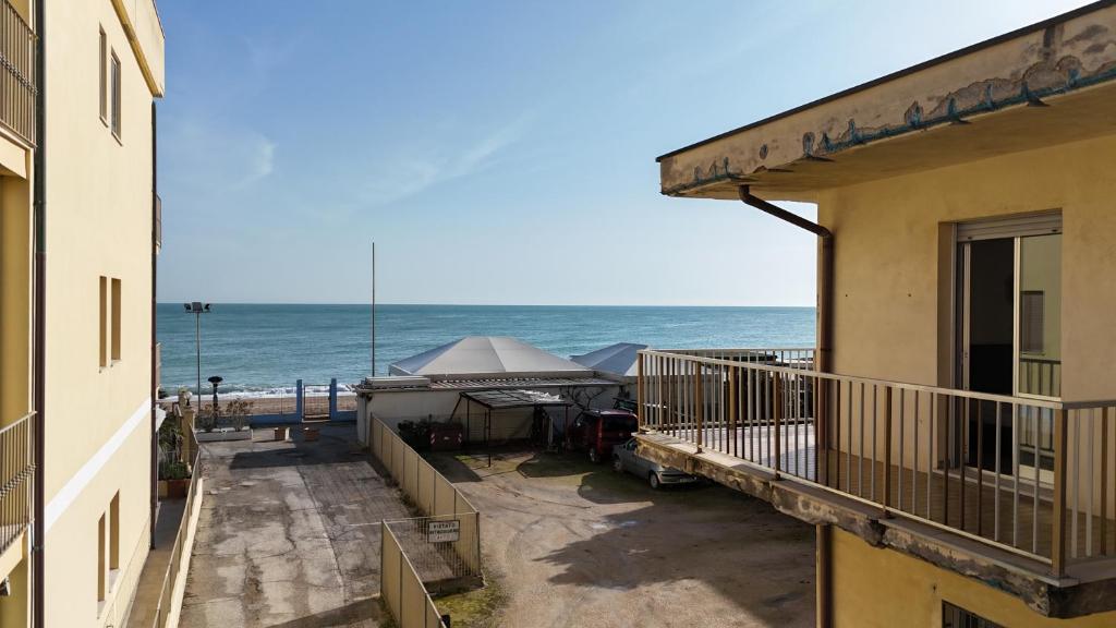 a view of the beach from the balcony of a building at Trilocale centro Marcelli fronte mare - M223 in Marcelli