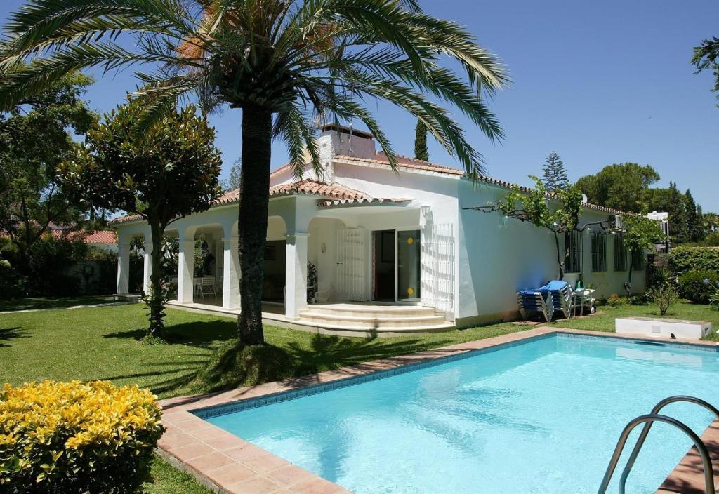 a villa with a swimming pool in front of a house at Beautiful Villa La Caracola in Marbella