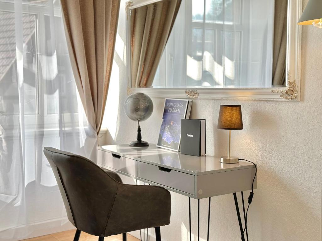 einen Glasschreibtisch mit einem Stuhl und einer Lampe in der Unterkunft Boutique Apartment • Zentrum • Netflix • Parkplatz in Bad Schandau