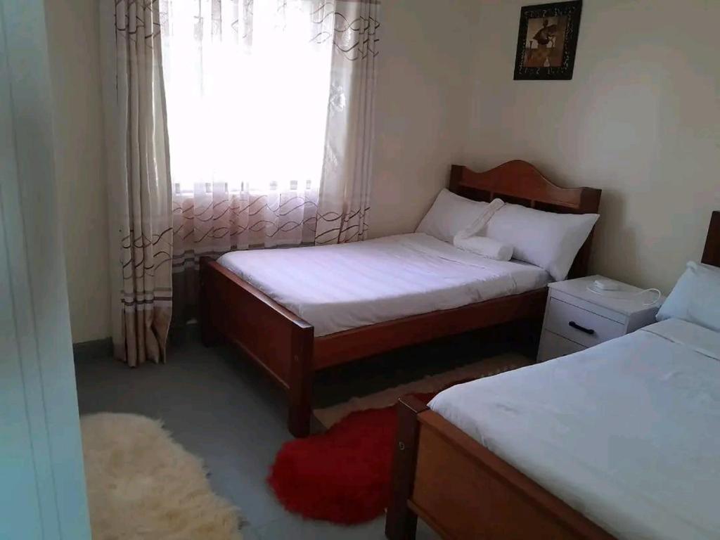 a small bedroom with two beds and a window at Mone Airbnb in Nambale