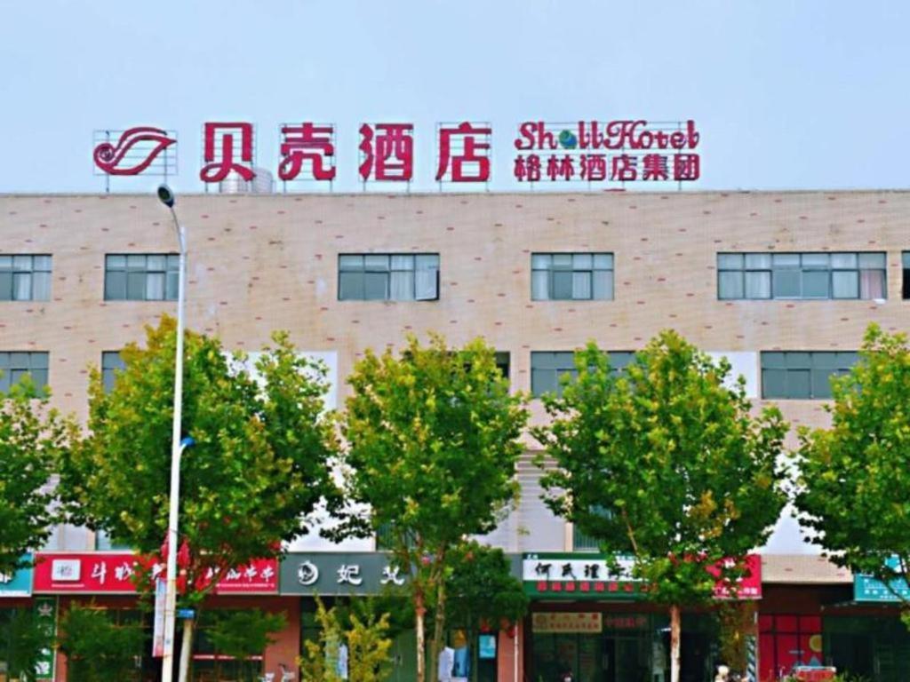un edificio con un cartel encima en Shell Hotel Wuhu Jiujiang District Daqiao Town Huashan Road en Wanli
