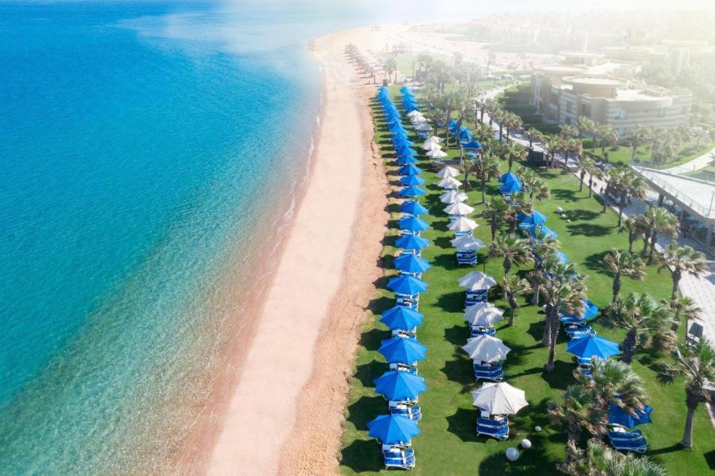 Grand Ocean Sokhna Hotel في العين السخنة: اطلالة جوية على شاطئ فيه مظلات والمحيط