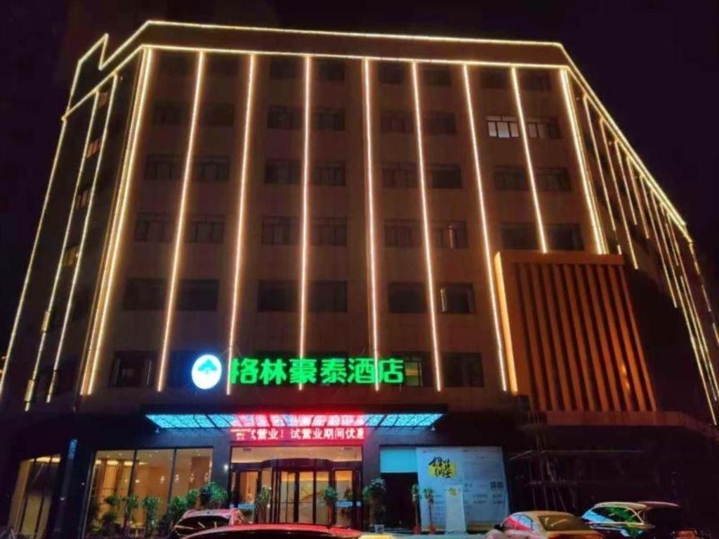 een groot gebouw met een bord ervoor bij GreenTree Inn Hubei Yangxin County Lianhua Lake Mingyue Bay in Yangxin