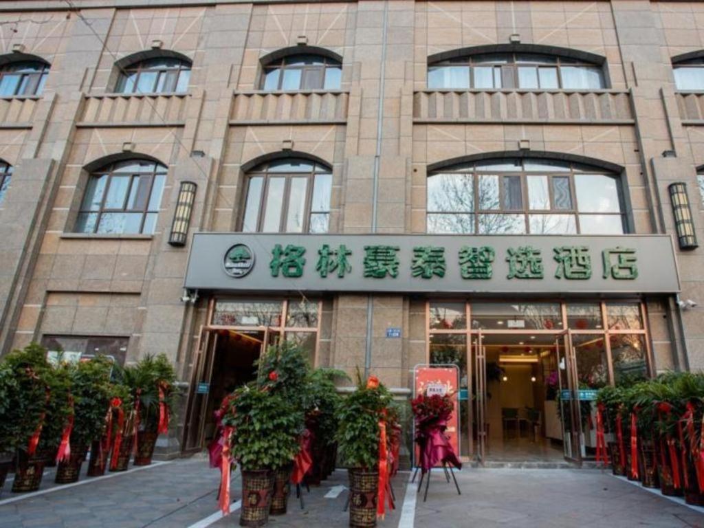 a building with plants in front of it at GreenTree Inn Express Jiangsu Suqian School Yingmadi Road in Suqian