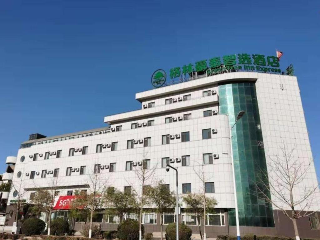 ein weißes Gebäude mit einem Schild darüber in der Unterkunft GreenTree Inn Express Liaoning Jinzhou Bijia Mountain in Dandong