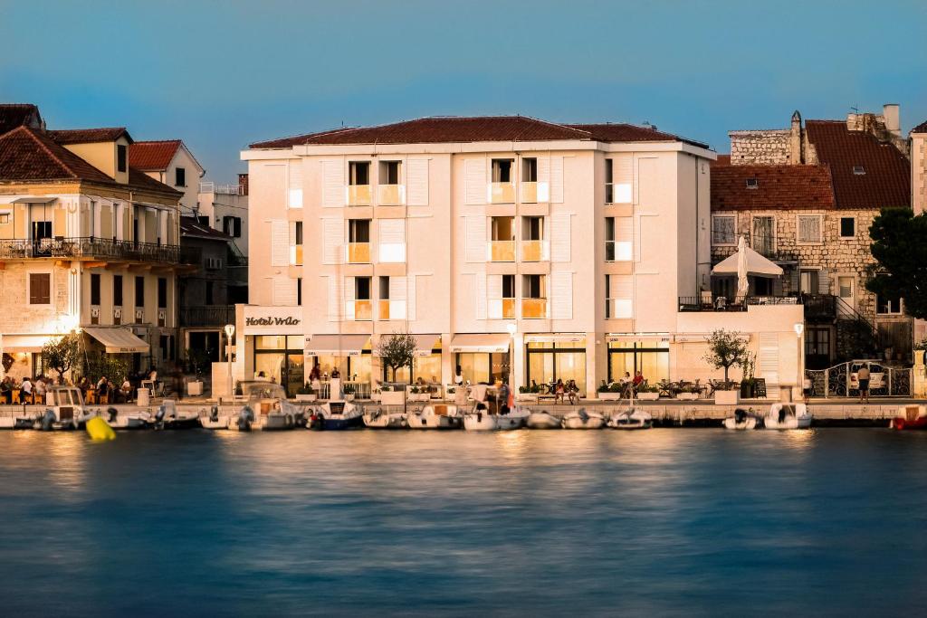 un groupe de bâtiments à côté d'une rivière dans l'établissement Hotel Vrilo - Adults Only, à Postira