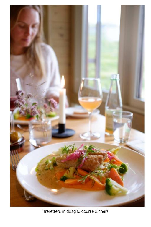 a woman sitting at a table with a plate of food at Turtagrø Hotel in Fortun