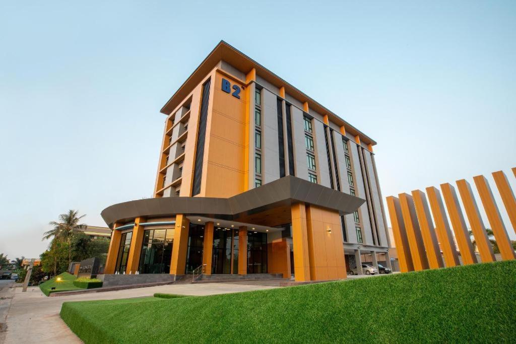 un bâtiment jaune avec une horloge au sommet dans l'établissement B2 Surat Thani Premier Hotel, à Surat Thani