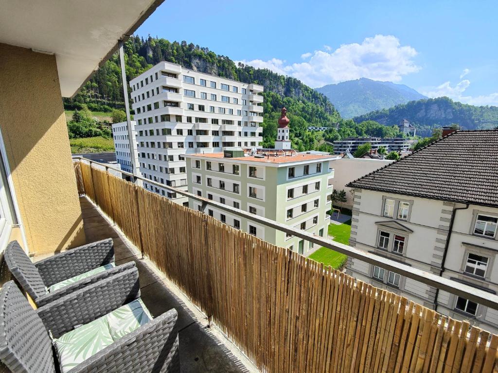 balcone con vista sugli edifici e sulle montagne. di 2 bedroom Apartment at Bahnhofcity a Feldkirch