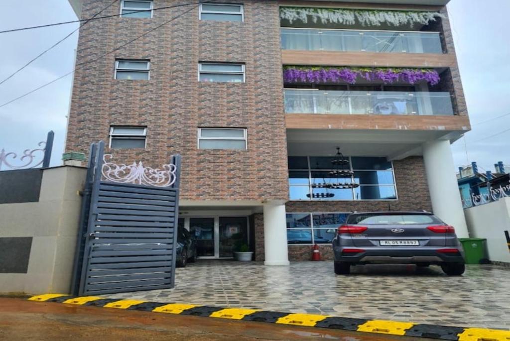 a building with a car parked in front of it at Hotel The Relyn Suite Shillong in Shillong
