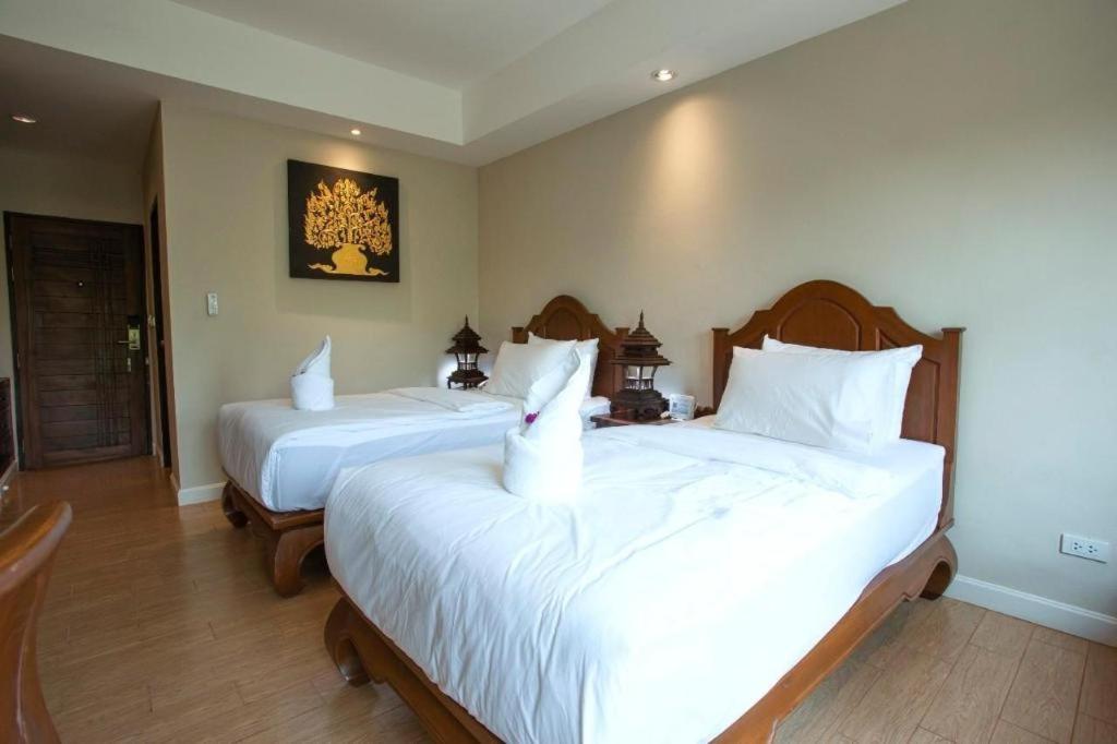 1 dormitorio con 2 camas con sábanas blancas en KOKHABURI HOTEL en Ban Chomphu