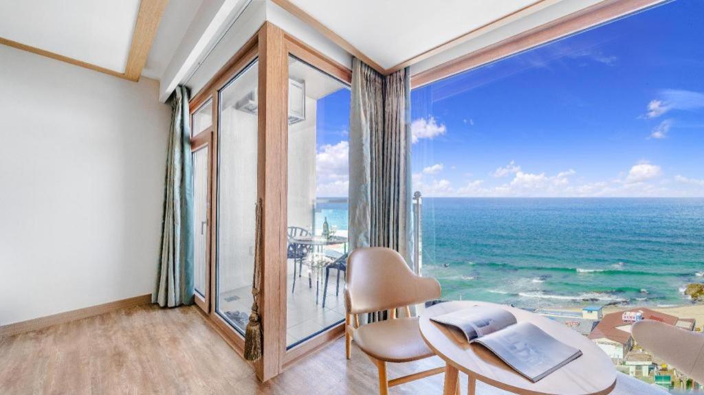 a room with a table and a view of the ocean at Gangneung Four Season Hotel and Pension in Gangneung