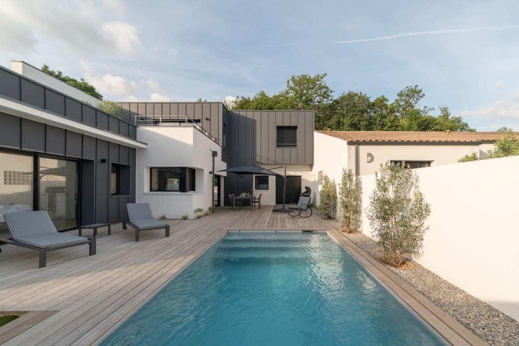 a swimming pool in the backyard of a house at L'Oasis - villa avec piscine chauffée classée 5* in Périgny