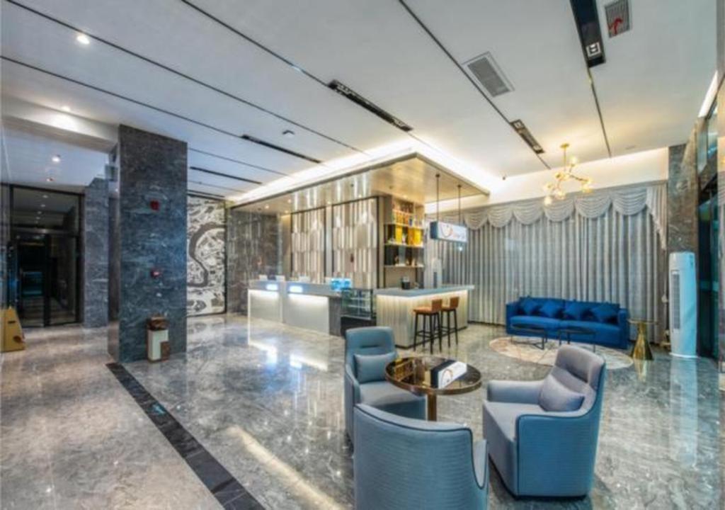 ein Wohnzimmer mit blauen Stühlen und einer Bar in der Unterkunft Echarm Hotel Liuzhou Liunan Wanda Plaza Liuyong Road in Liuzhou