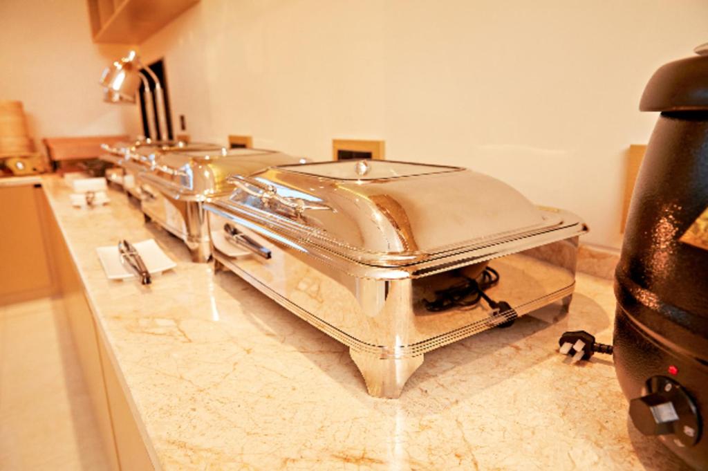 a row of stainless steel food pans on a counter at City Comfort Inn Changchun 3rd Bethune Hospital of Jilin University Zhongdong in Changchun