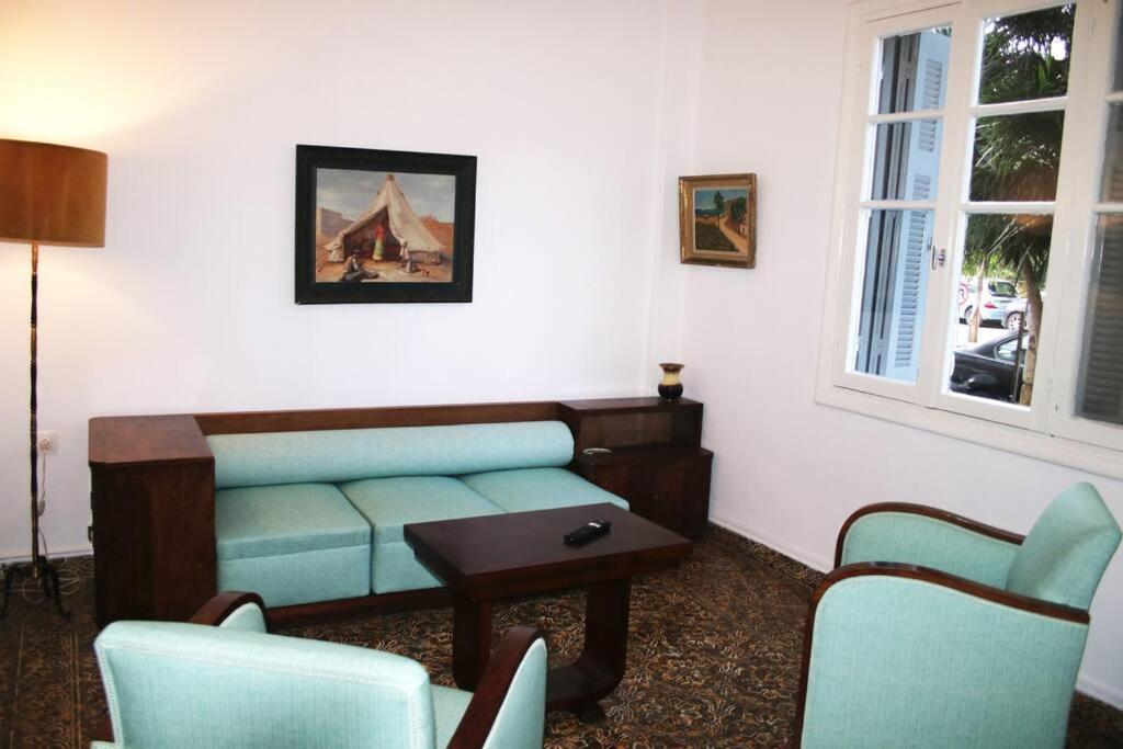 een woonkamer met een bank, stoelen en een tafel bij Amazing Centrally Located Apartment in Heraklion