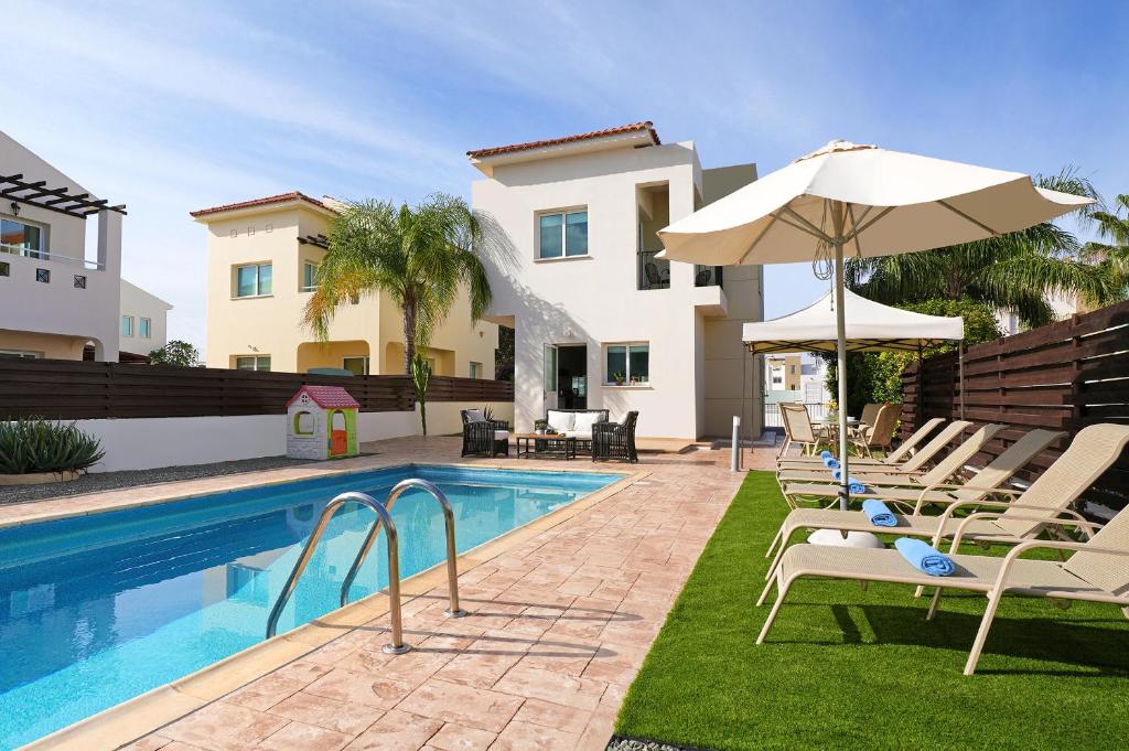 een villa met een zwembad met stoelen en een parasol bij Villa Summer in Protaras
