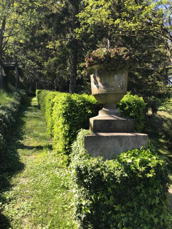 a stone vase sitting on top of a hedge at Dimora Storica La Corte Delle 4 Stagioni in Ozzano Monferrato