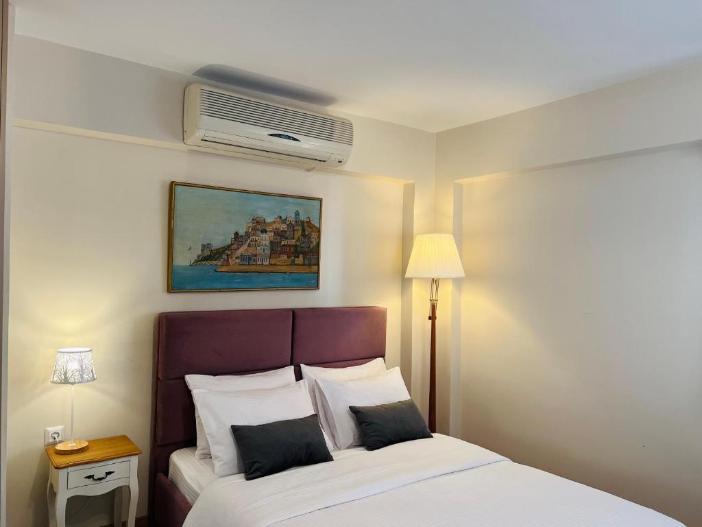 a hotel room with a bed and a air conditioner at Vasilias Home near Ath Airport in Koropi