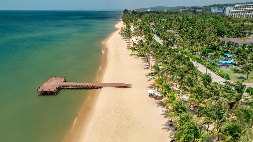 eine Luftblick auf einen Strand mit Palmen in der Unterkunft Andochine Villas Resort & Spa Phu Quoc - All Villas with Private Pool in Phu Quoc