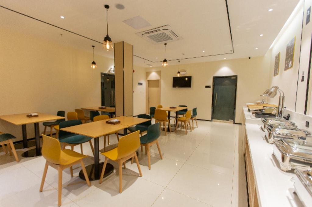 a restaurant with tables and chairs in a room at City Comfort Inn Shaoguan Biguiyuan Phoenix City Gold Village in Shaoguan