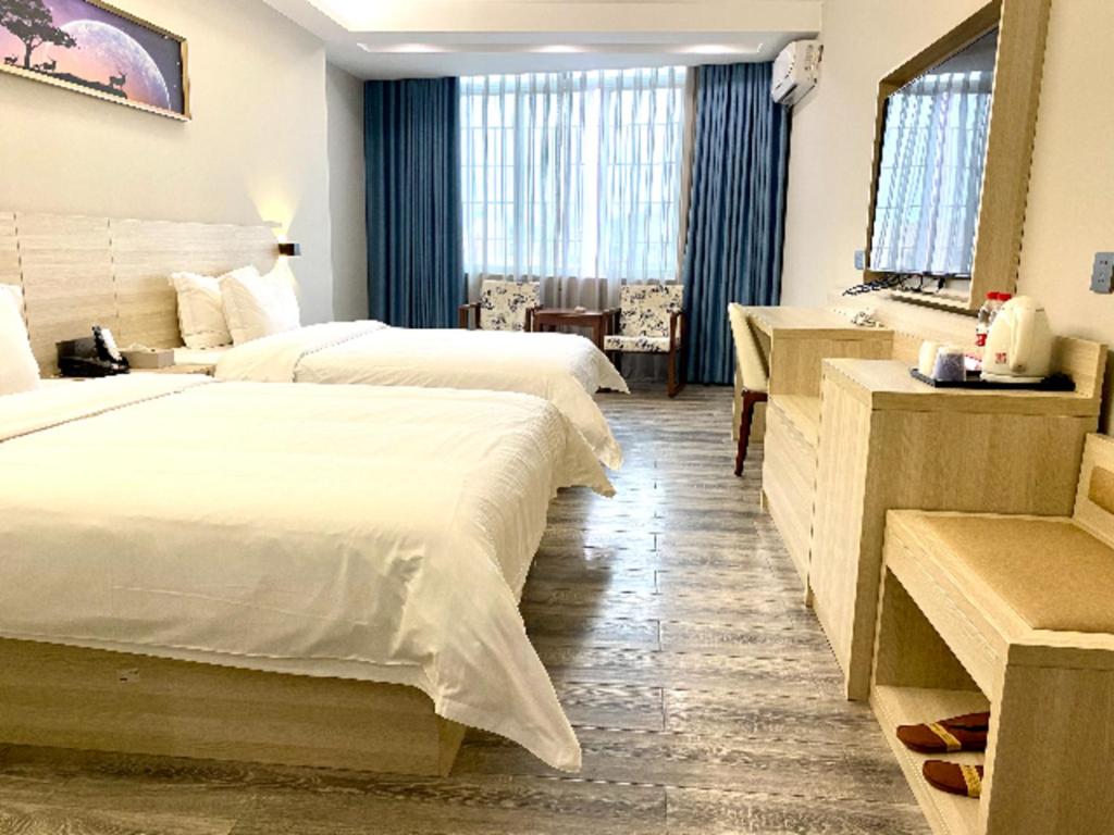 a hotel room with two beds and a bathroom at JTOUR Inn Maoming Huazhou Beijing Road Railway Station in Sanguantang